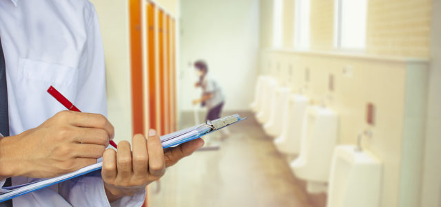 Man with Cleaning List in Bathroom