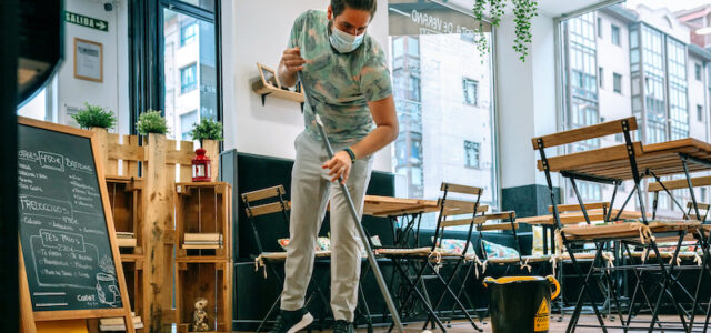10 Signs Your Restaurant Has a Lingering Odor Problem Worker with mask mopping the floor of a restaurant