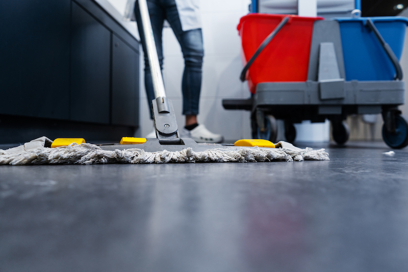 Microfiber mop cleaning floors of commercial restroom