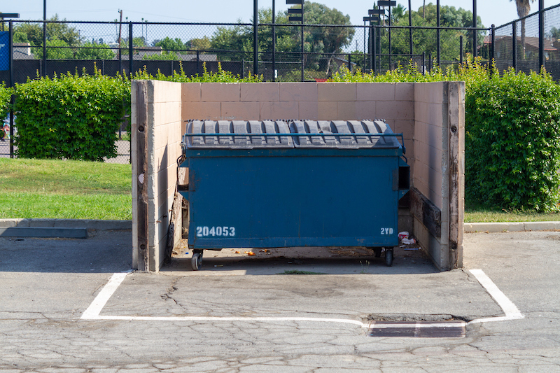 La Habra, CA, USA – July 12, 2021: A commercial trash bin with locked lid in a city park in La Habra, California.