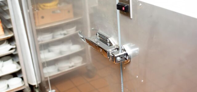 Outside of commercial freezer with focus on the door latch