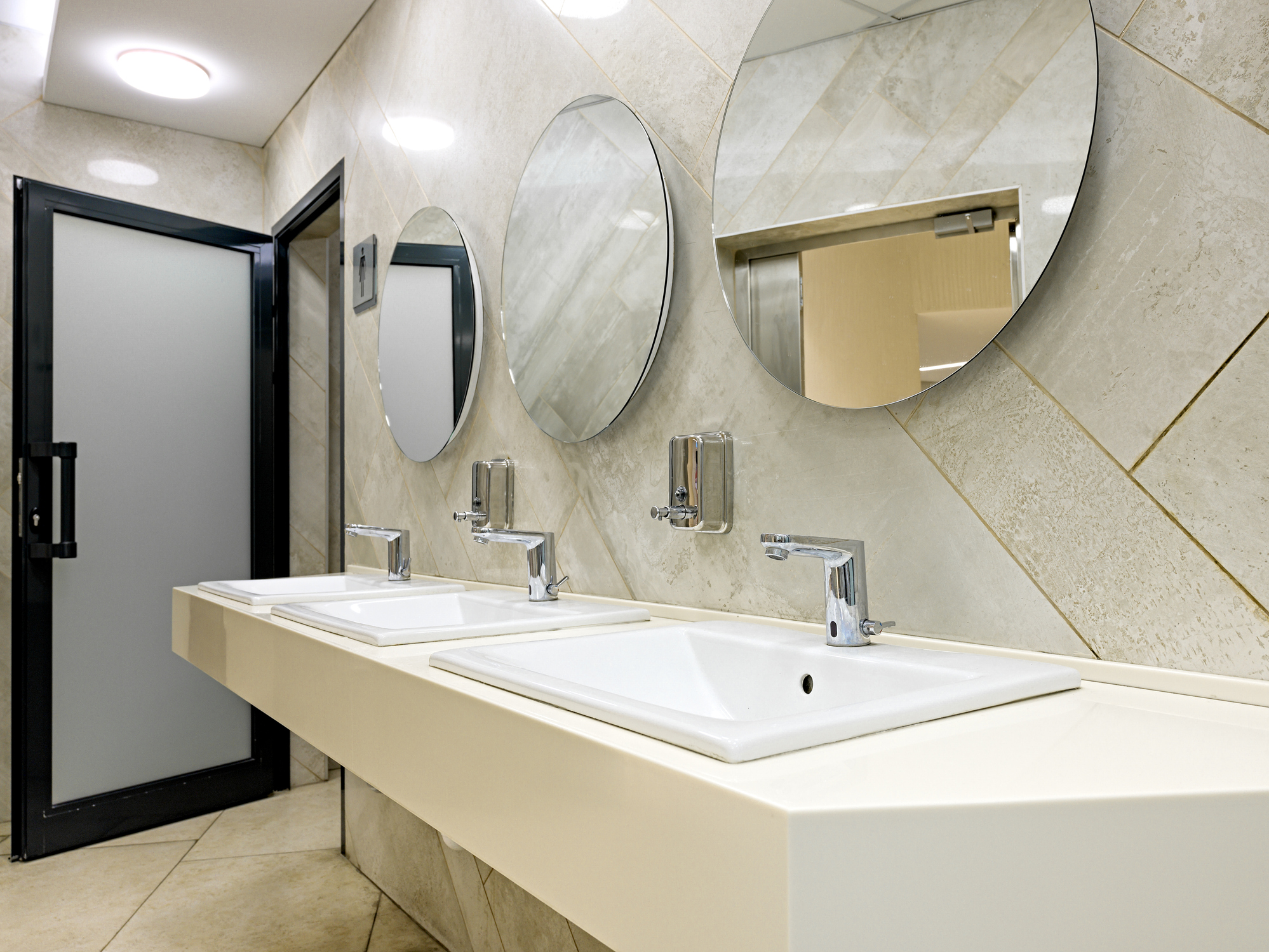 Public restroom with sinks faucets and mirrors