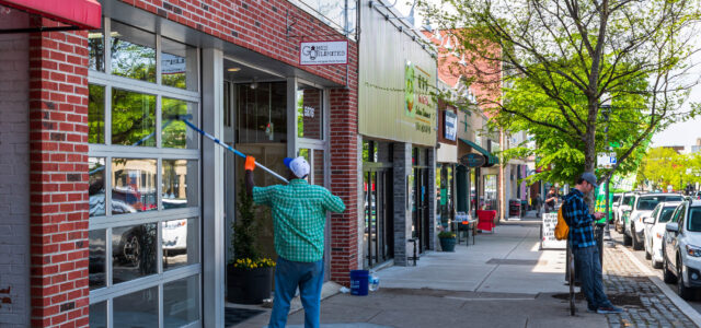 A street scene with a man washing a store's windows Pittsburgh, Pennsylvania, USA