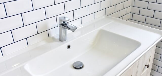 Modern bathroom Interior with design washbasin on a background of white ceramic tiles. Faucet for water at the white wall background.