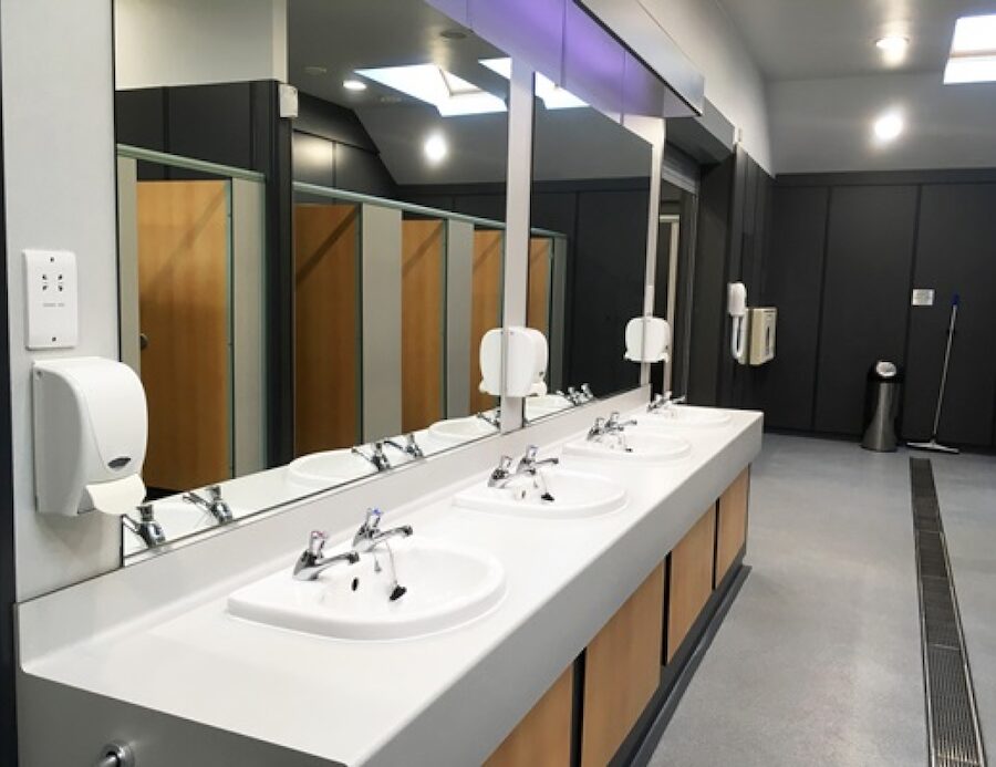 A row of clean sinks in a public bathroom. 