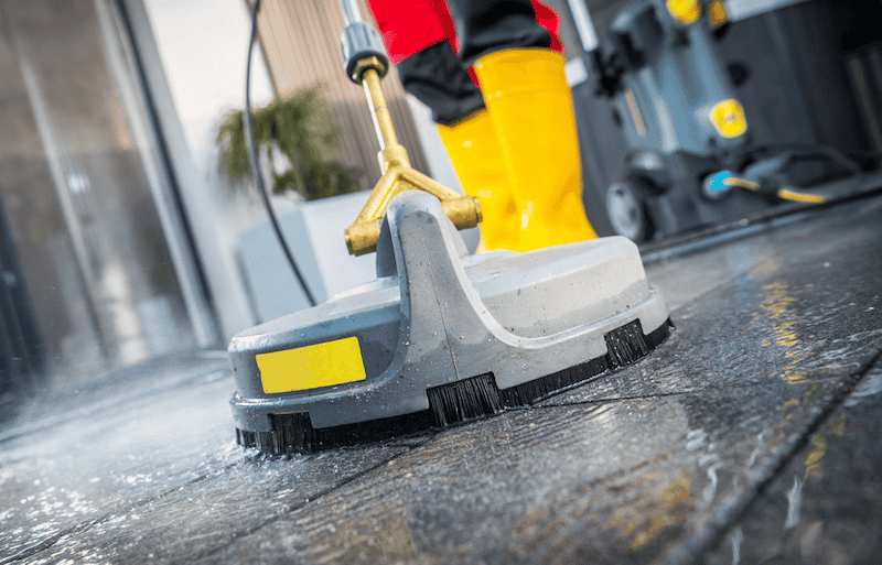 An Enviro-Master professional washes a gray tile floor.